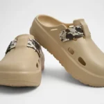 Vista frontal de par de zuecos de plataforma Concept Shoes en color beige topo con empeine liso y correa de estampado cowprint sobre fondo blanco.