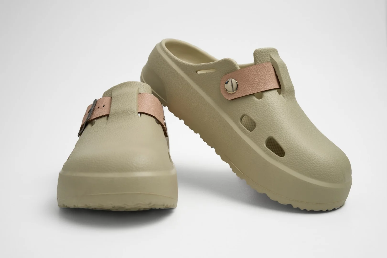 Vista frontal de par de zuecos de plataforma Concept Shoes en color hueso con empeine liso y correa tonal sobre fondo blanco.