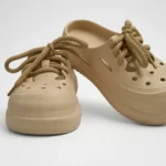 Vista frontal de par de zuecos de plataforma Concept Shoes en color beige topo texturizados con audaces cordones de soga sobre fondo blanco.